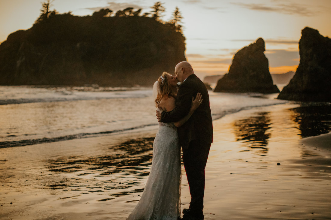 bride and groom kissing at the beach