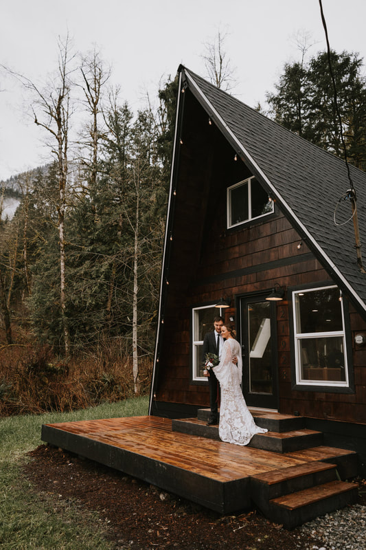 bride and groom in front of pnw cabin